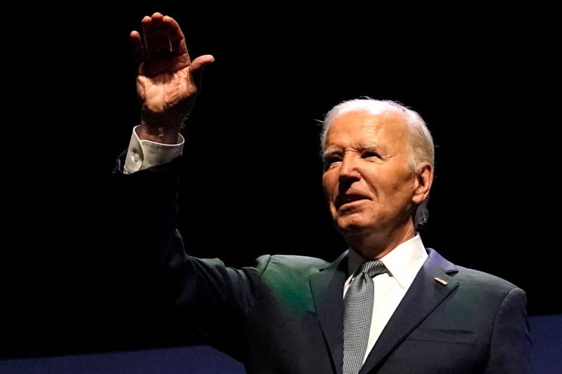 US President Joe Biden waves on stage (Photo by KENT NISHIMURA/AFP via Getty Images)